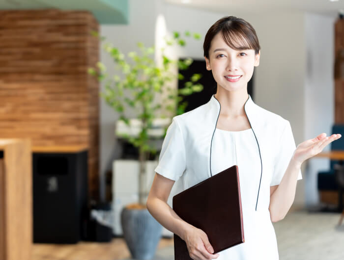 清潔感のある白衣を着た女性スタッフが、スキンケアについて案内している様子